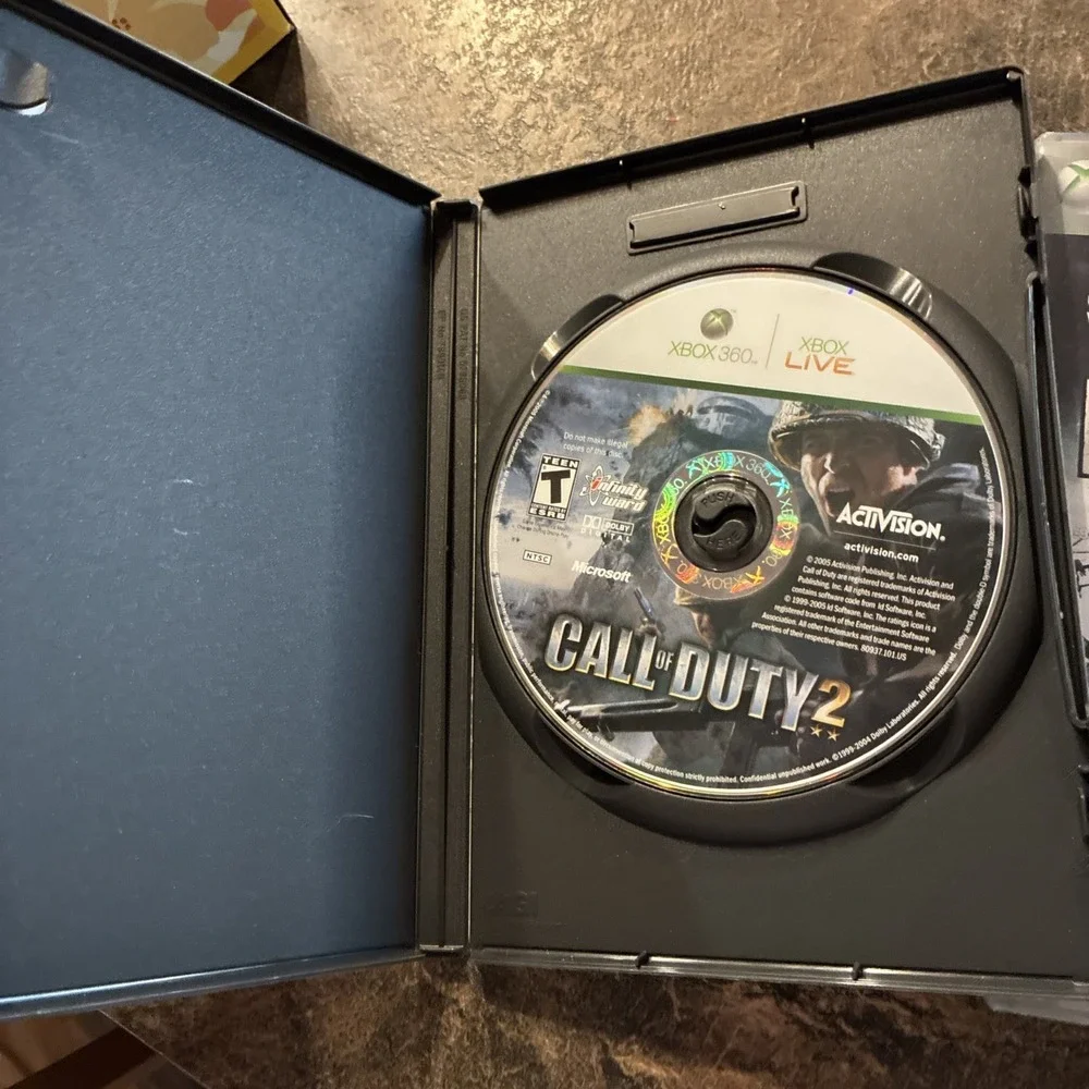 Three Xbox 360 Games, Assassin Creed, Battlefield, And Call Of Duty